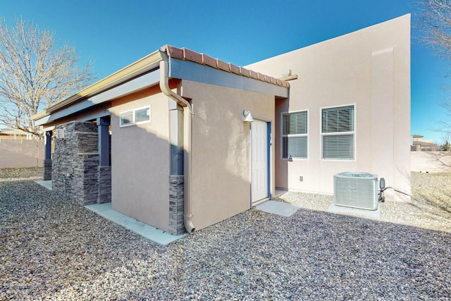 view of side of home with central AC unit