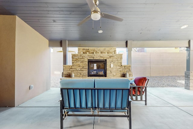 view of patio with an outdoor living space with a fireplace and ceiling fan