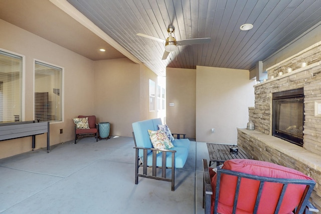 view of patio with an outdoor living space with a fireplace and ceiling fan