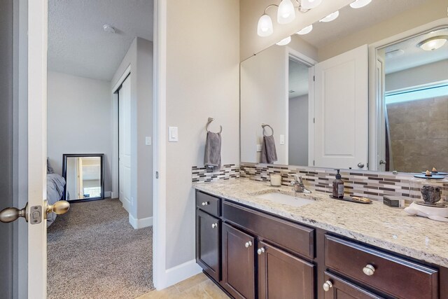 bathroom featuring vanity, a textured ceiling, and tasteful backsplash