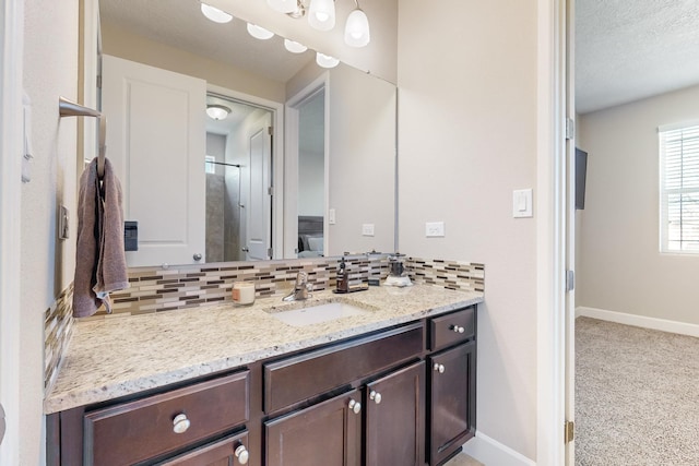 bathroom with decorative backsplash, a textured ceiling, and vanity