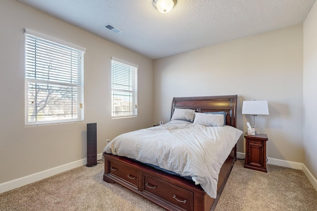 bedroom with light carpet and a textured ceiling