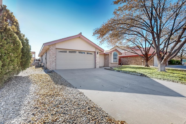 ranch-style home with cooling unit and a garage