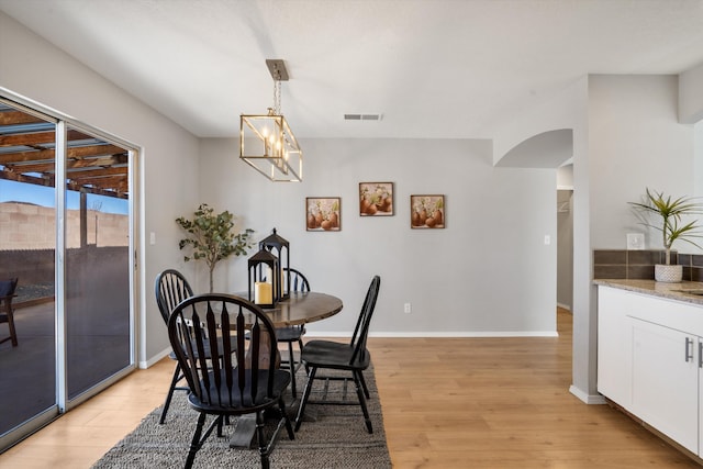 dining room featuring an inviting chandelier and light hardwood / wood-style flooring