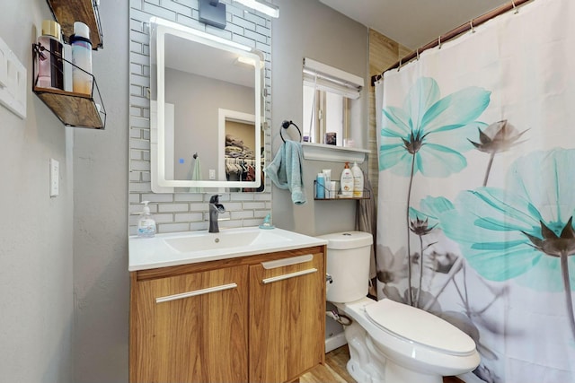 bathroom featuring a shower with curtain, backsplash, hardwood / wood-style floors, toilet, and vanity