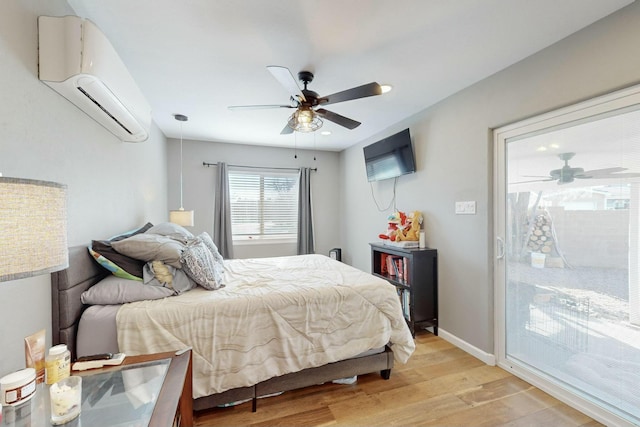 bedroom featuring access to exterior, light hardwood / wood-style floors, a wall unit AC, and ceiling fan