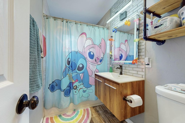 full bathroom with shower / bath combo, toilet, decorative backsplash, vanity, and hardwood / wood-style flooring