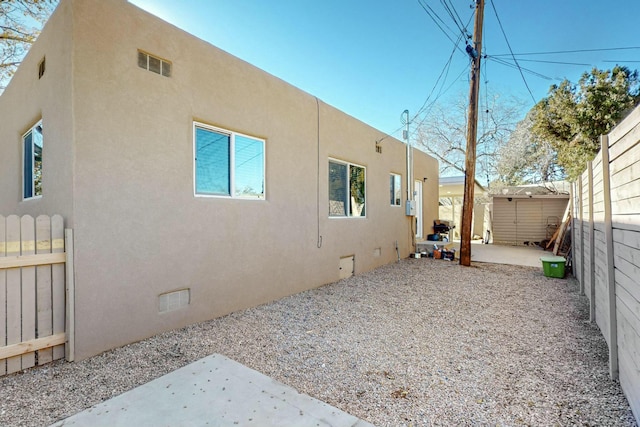 view of side of property with a shed and a patio