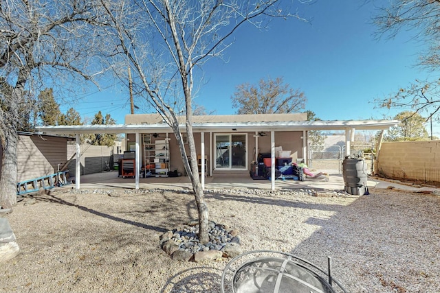 rear view of property with ceiling fan and a patio