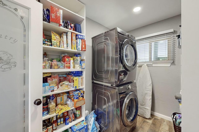 laundry room with stacked washing maching and dryer and wood-type flooring