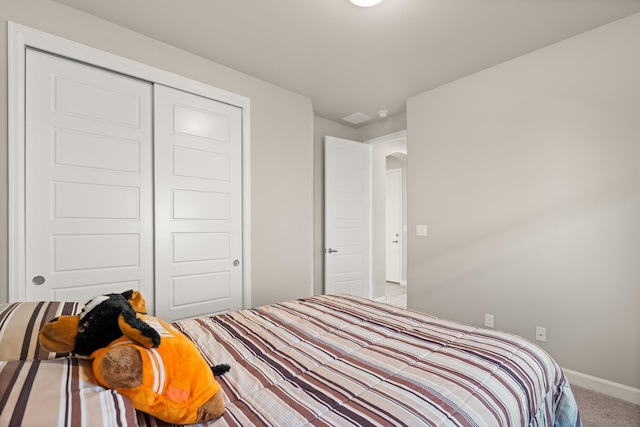 bedroom with a closet and light carpet