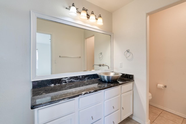 bathroom with tile patterned flooring, vanity, and toilet