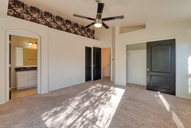 unfurnished bedroom with connected bathroom, light carpet, ceiling fan, and vaulted ceiling