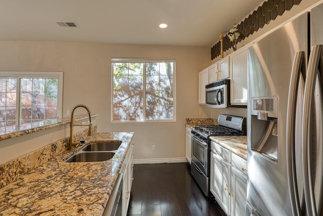 kitchen with white cabinetry, light stone countertops, sink, stainless steel appliances, and plenty of natural light