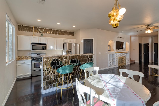 dining room with dark hardwood / wood-style flooring and ceiling fan