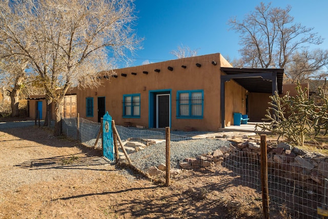 back of house with fence and stucco siding