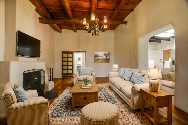 living room featuring a notable chandelier, dark hardwood / wood-style flooring, wood ceiling, and beamed ceiling