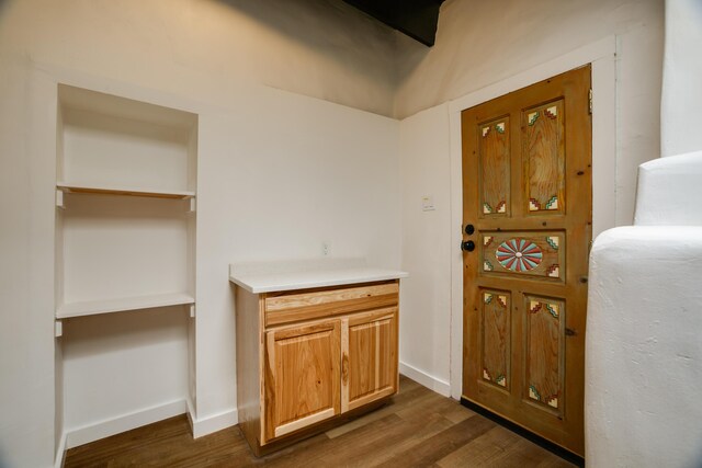 kitchen featuring appliances with stainless steel finishes, light wood-type flooring, a fireplace, beam ceiling, and sink