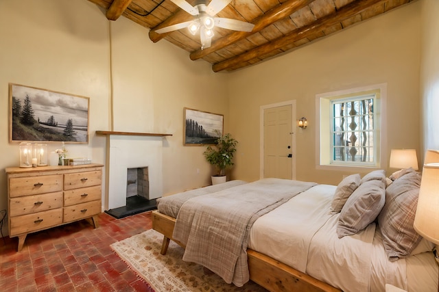 bedroom featuring a fireplace with raised hearth, brick floor, beamed ceiling, and wooden ceiling