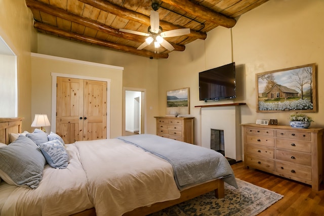 bedroom with ceiling fan, dark hardwood / wood-style floors, beamed ceiling, and wooden ceiling