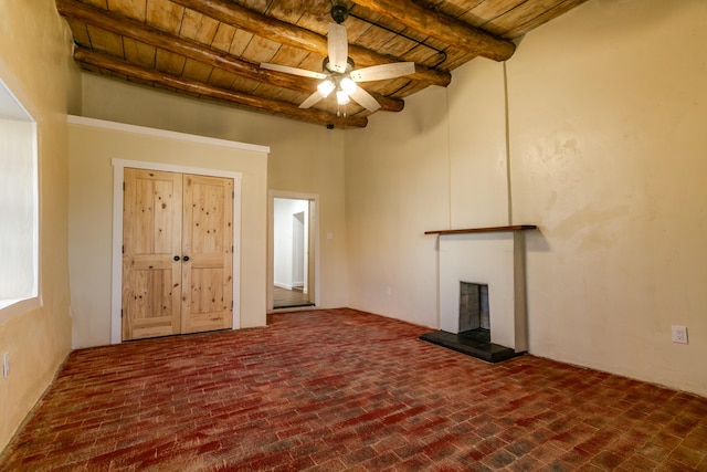 unfurnished living room with a fireplace with raised hearth, beamed ceiling, brick floor, and wood ceiling