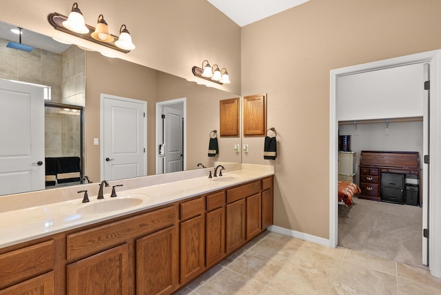 bathroom with a tile shower, double vanity, tile patterned flooring, and a sink