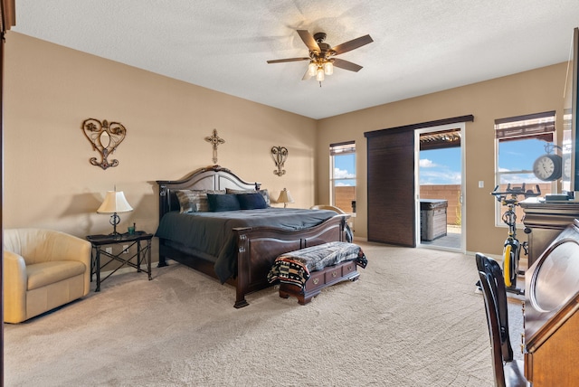 carpeted bedroom featuring access to exterior, a textured ceiling, and ceiling fan