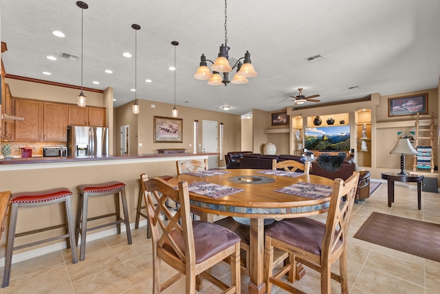 tiled dining room featuring ceiling fan with notable chandelier and a textured ceiling