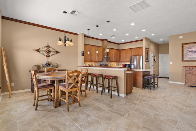 dining room featuring light tile patterned flooring, ornamental molding, a textured ceiling, and an inviting chandelier