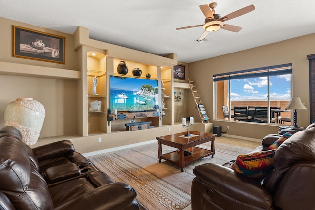 living room featuring ceiling fan, built in features, and a textured ceiling