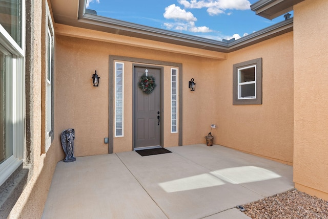 property entrance featuring a patio and stucco siding