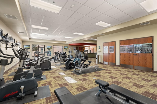 exercise room featuring carpet, a drop ceiling, and visible vents