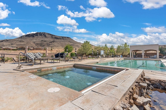 view of swimming pool with a patio area and a mountain view