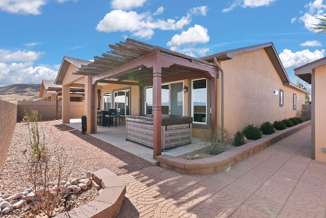 view of patio featuring a hot tub, a pergola, outdoor dining area, and a fenced backyard