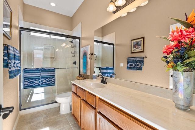 bathroom with tile patterned floors, vanity, an enclosed shower, and toilet