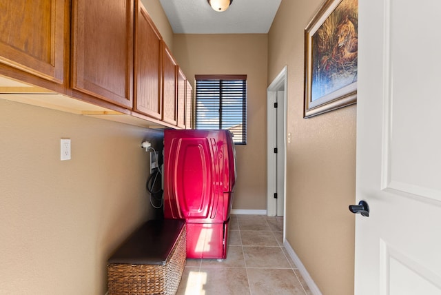 clothes washing area featuring cabinets, washer / clothes dryer, and light tile patterned flooring