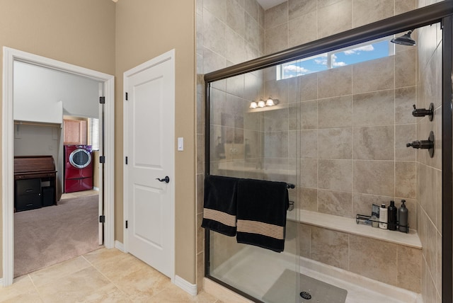 bathroom featuring tile patterned flooring, an enclosed shower, and washer / dryer