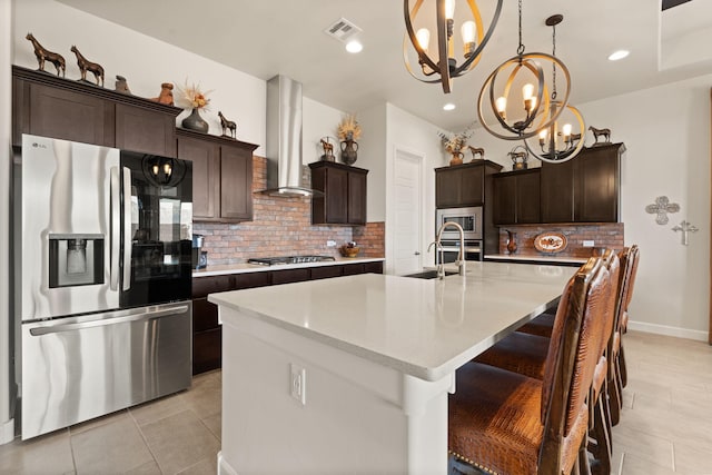 kitchen with appliances with stainless steel finishes, backsplash, a notable chandelier, visible vents, and ventilation hood