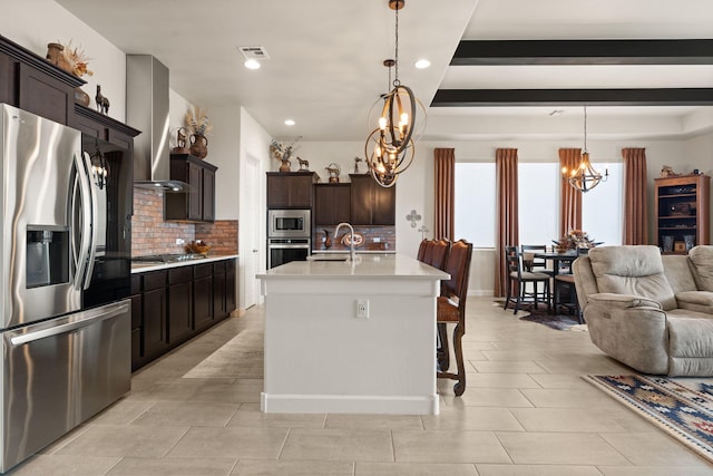 kitchen with stainless steel appliances, extractor fan, decorative backsplash, a chandelier, and open floor plan