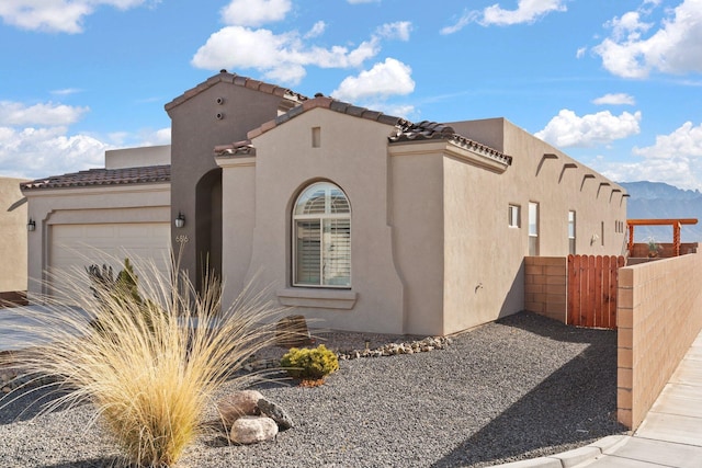 view of side of property with a mountain view and a garage