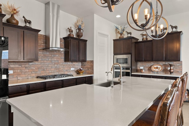 kitchen with stainless steel appliances, dark brown cabinets, light countertops, and range hood