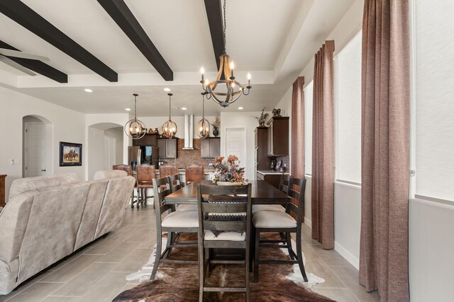 dining space featuring a chandelier, arched walkways, beam ceiling, and recessed lighting