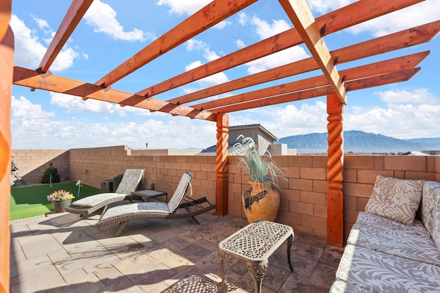 view of patio featuring a fenced backyard, a mountain view, and a pergola