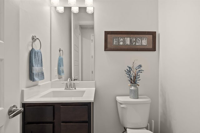 half bathroom with vanity and toilet