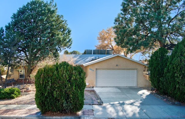 view of front of house with driveway, an attached garage, and stucco siding