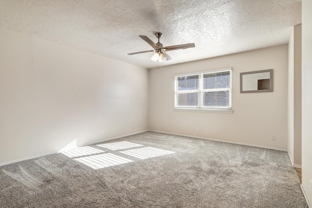 spare room with carpet, a textured ceiling, baseboards, and a ceiling fan