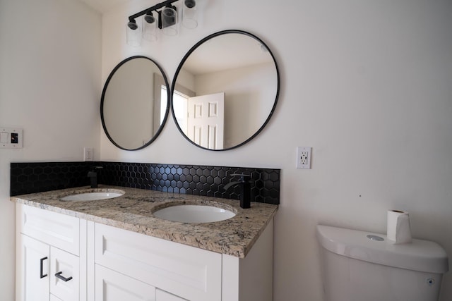 bathroom with vanity, toilet, and backsplash