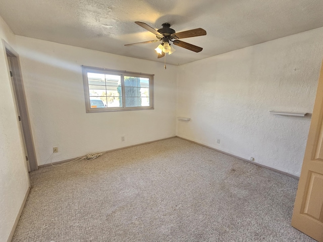 carpeted empty room with ceiling fan and a textured ceiling