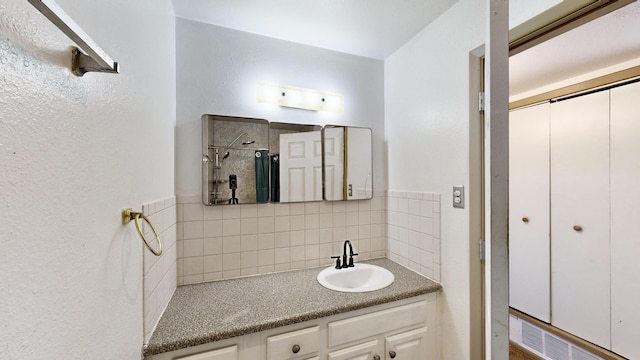 bathroom featuring vanity, tasteful backsplash, and walk in shower