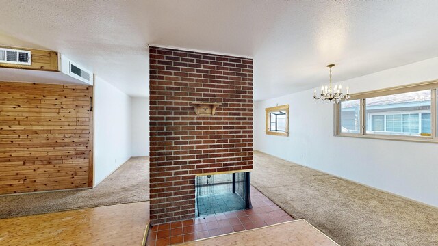 hall featuring a chandelier, a textured ceiling, and dark colored carpet